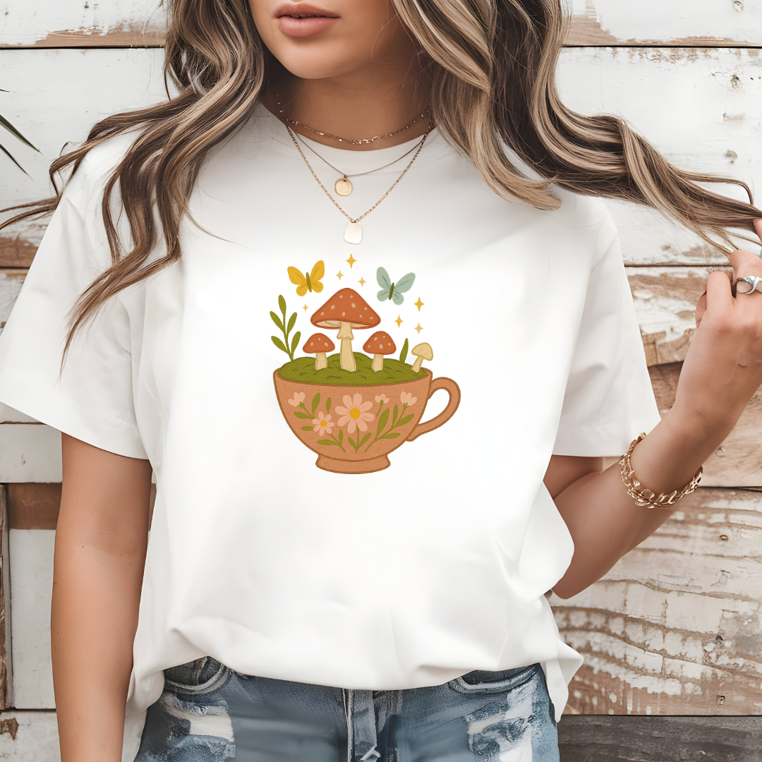 Person wearing a white t-shirt with a cup and mushrooms design.